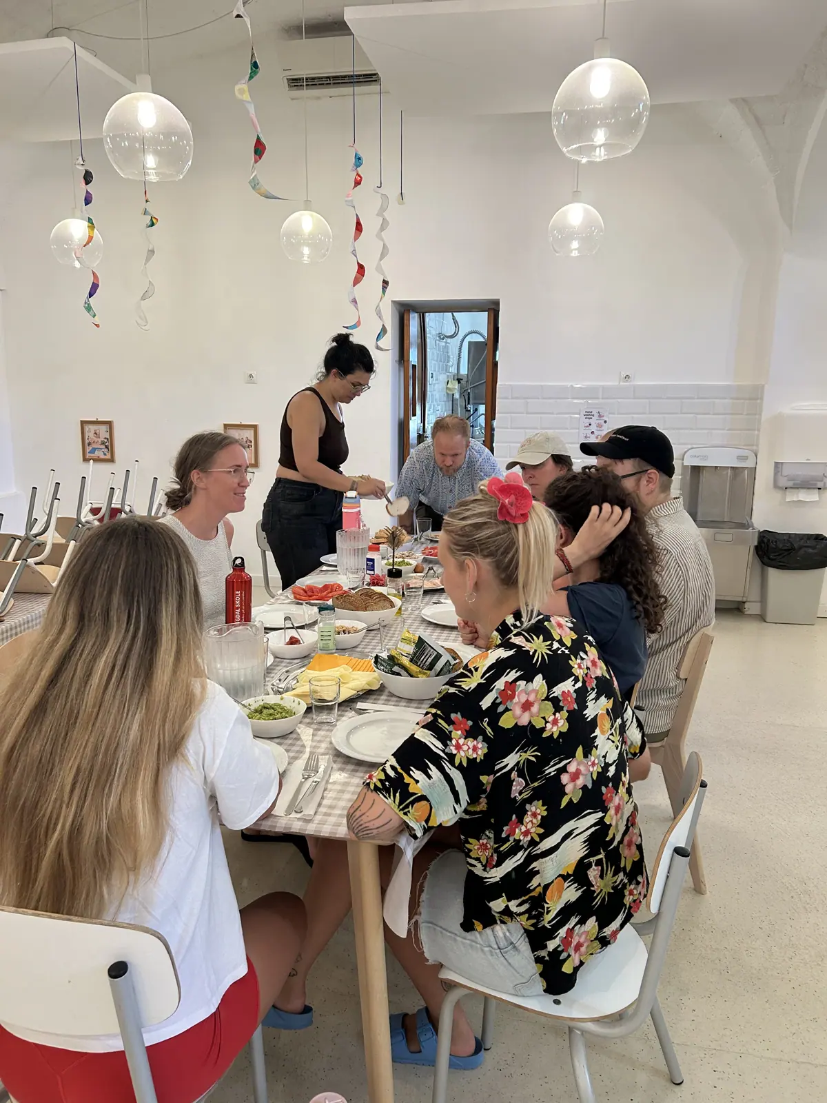 la promoción compartiendo una larga comida bajo decoraciones de papel