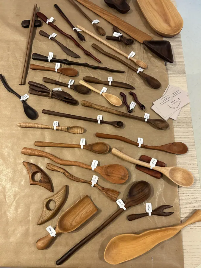 hileras de cucharas de madera talladas a mano, dispuestas y etiquetadas