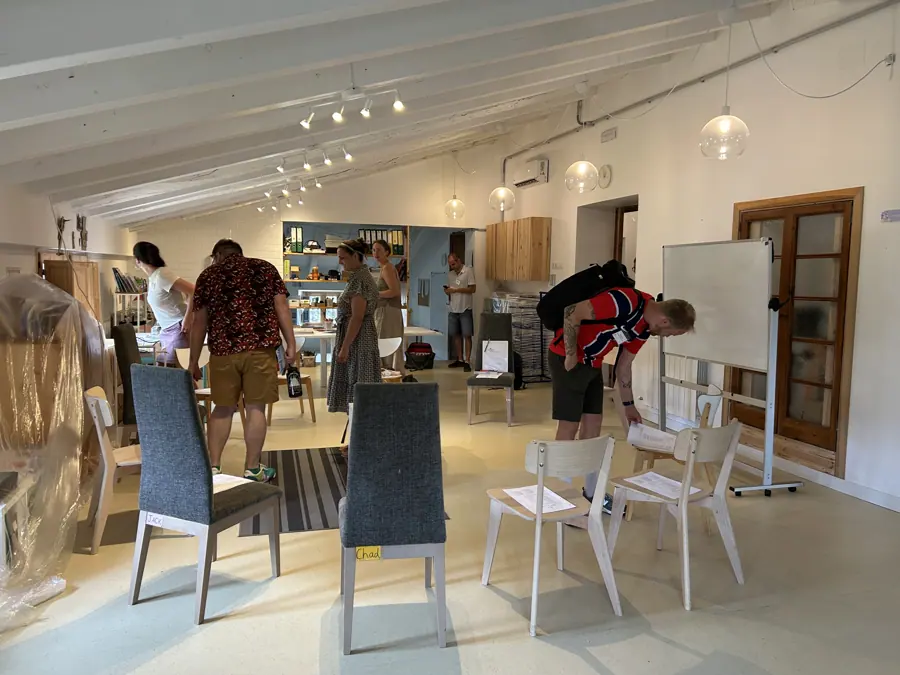 una sala luminosa con participantes moviéndose entre las mesas