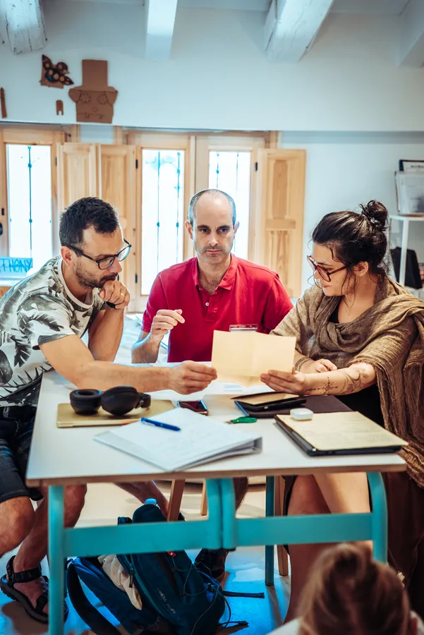 a small group working around a table with materials