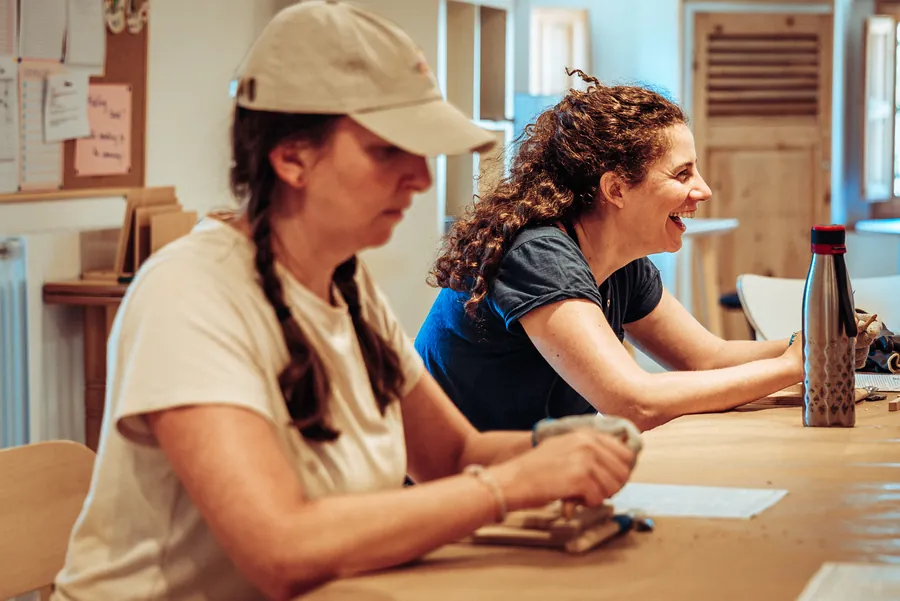 two participants laughing as they carve at the workshop table